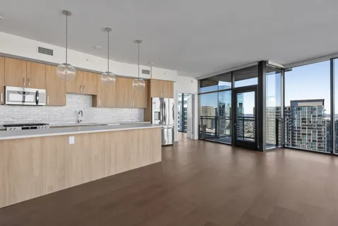 a large kitchen with a large window a sink and cabinets