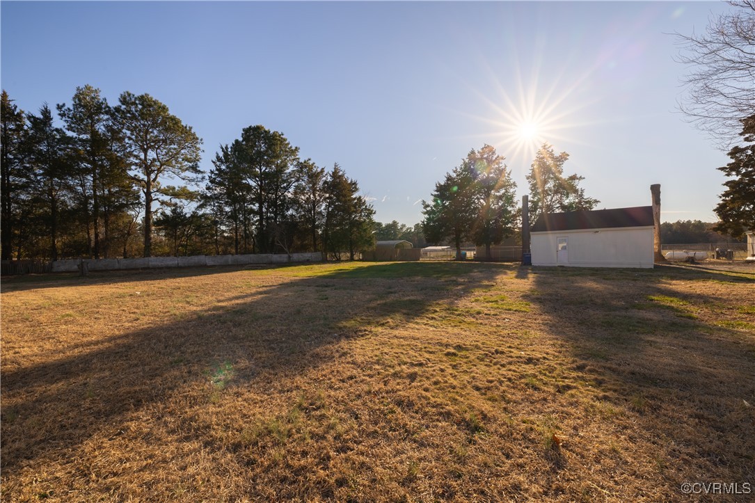 5501 West Quaker Road Disputanta, VA 23842 - Photo 6 of 26 View of yard with an outdoor structure and fence