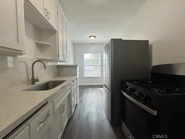 a kitchen with stainless steel appliances granite countertop a sink stove and refrigerator