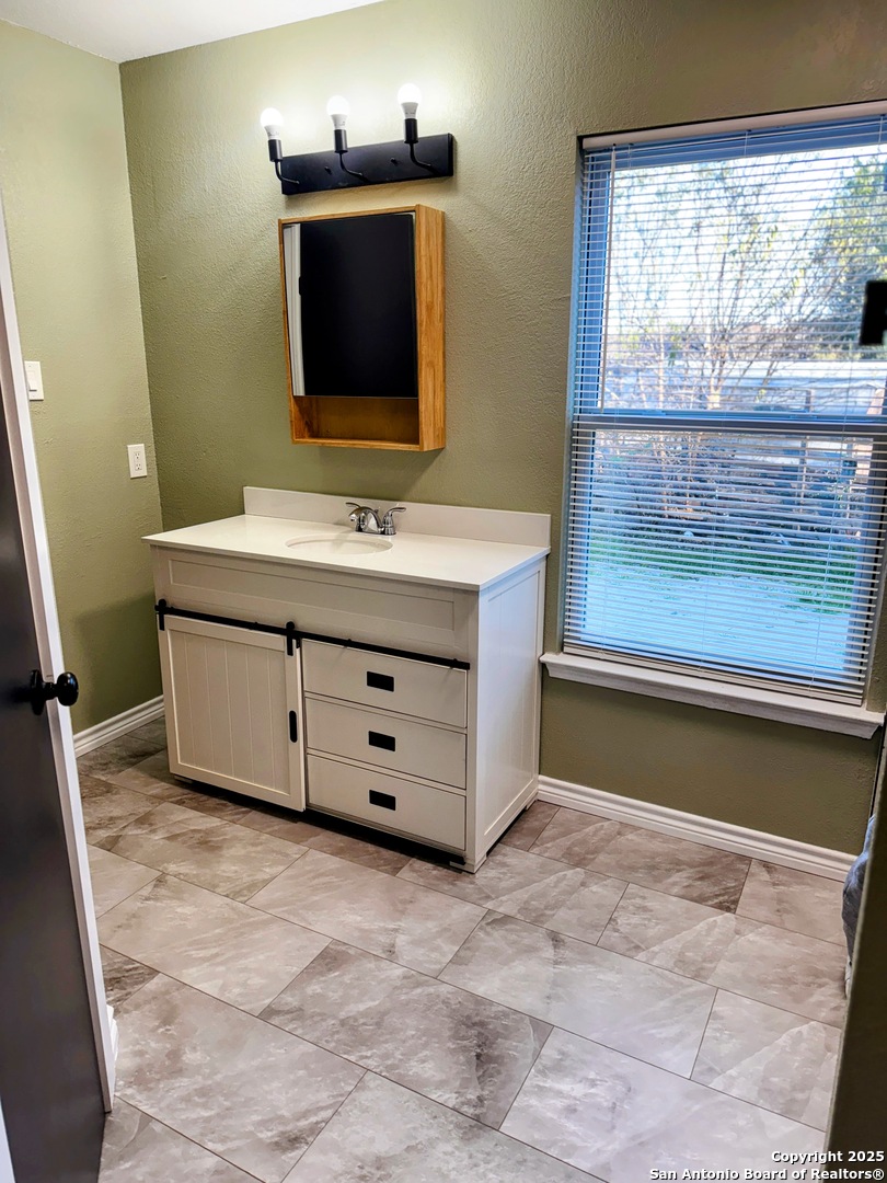 7935 Sonny Ridge San Antonio, TX 78244 - Photo 19 of 22 a bathroom with a tub sink and mirror