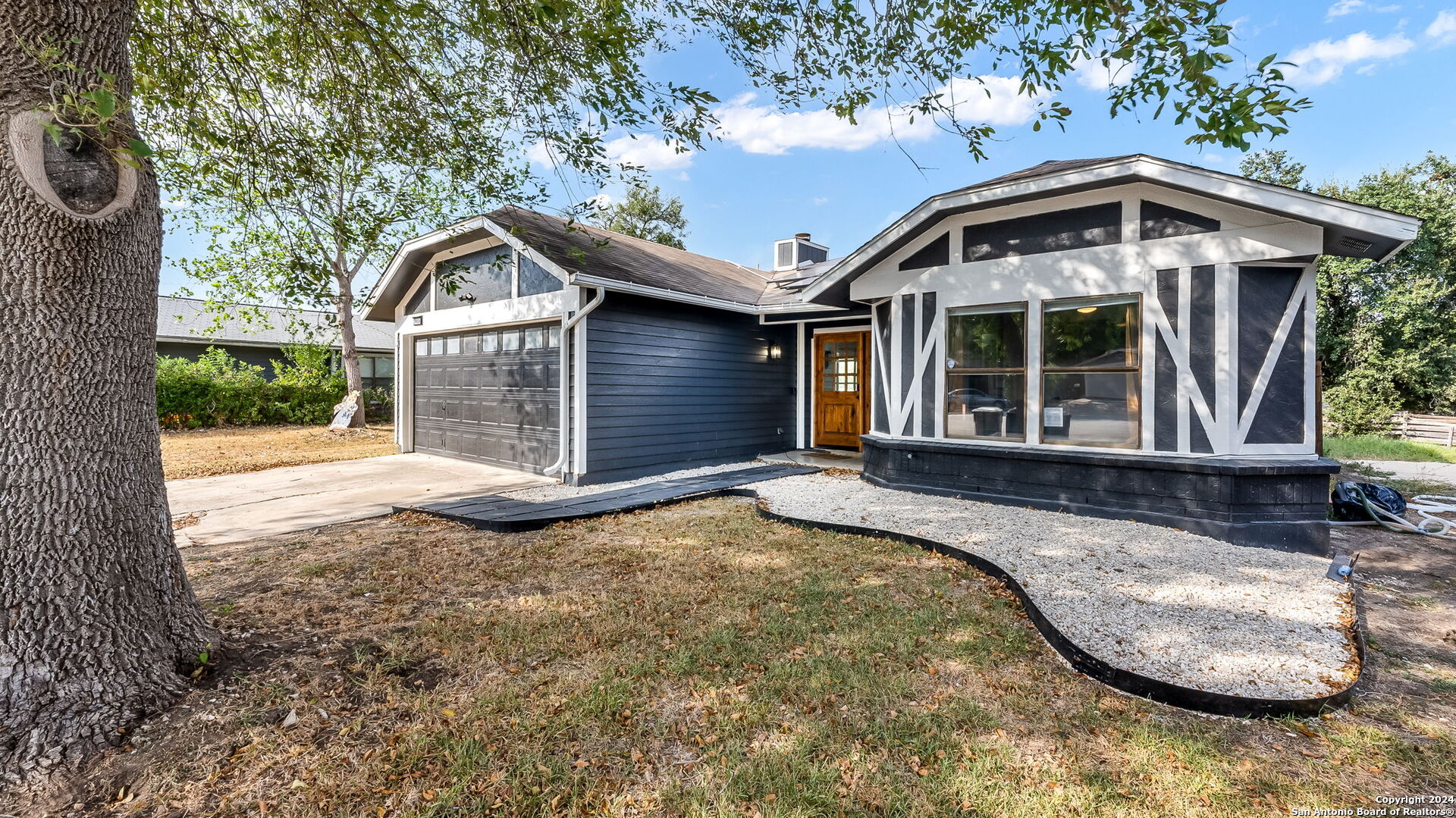 7935 Sonny Ridge San Antonio, TX 78244 - Photo 2 of 22 a front view of a house with a garden and yard