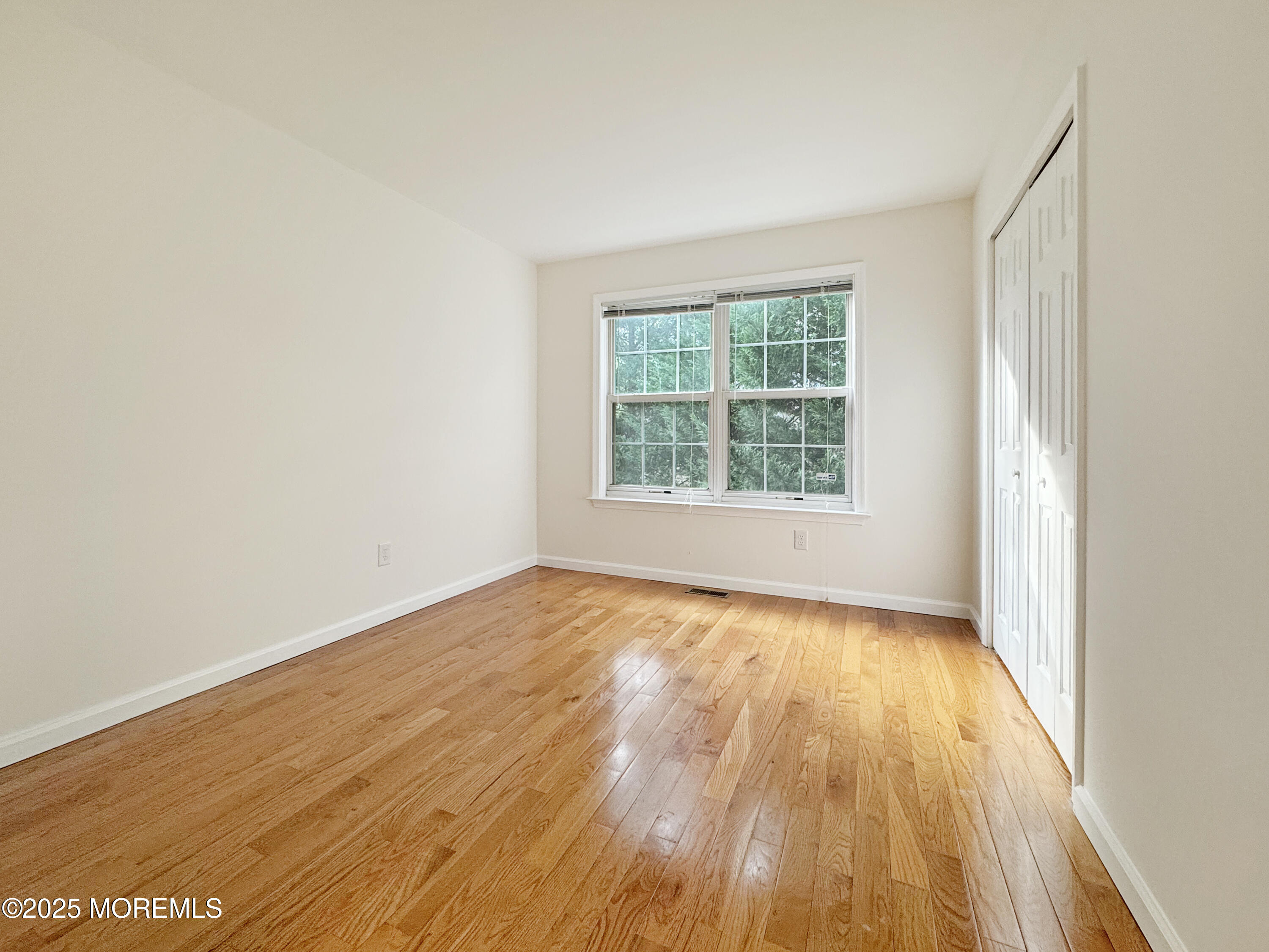 577 Windflower Court Morganville, NJ 07751 - Photo 15 of 27 an empty room with wooden floor and windows
