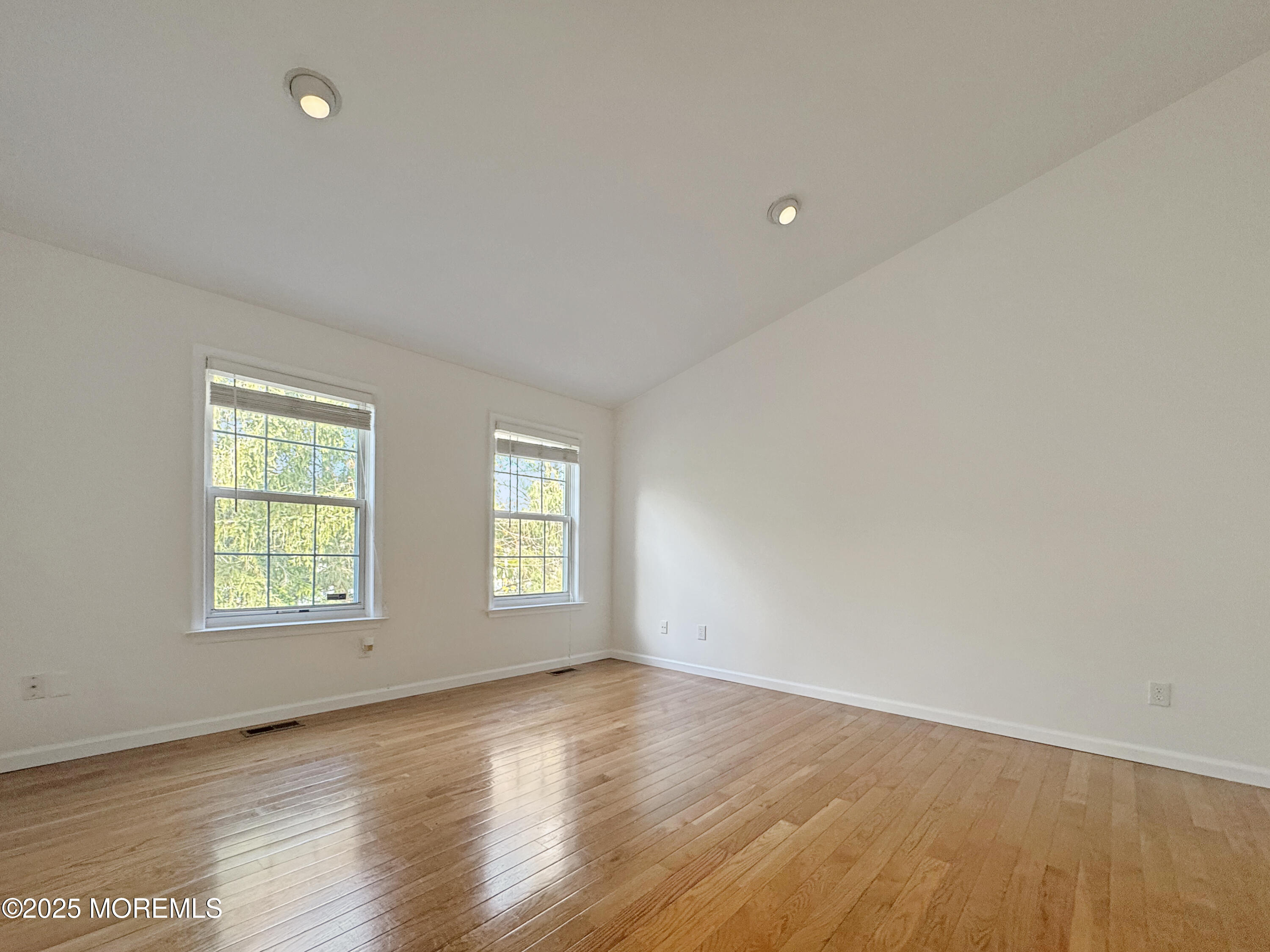 577 Windflower Court Morganville, NJ 07751 - Photo 18 of 27 an empty room with wooden floor and windows