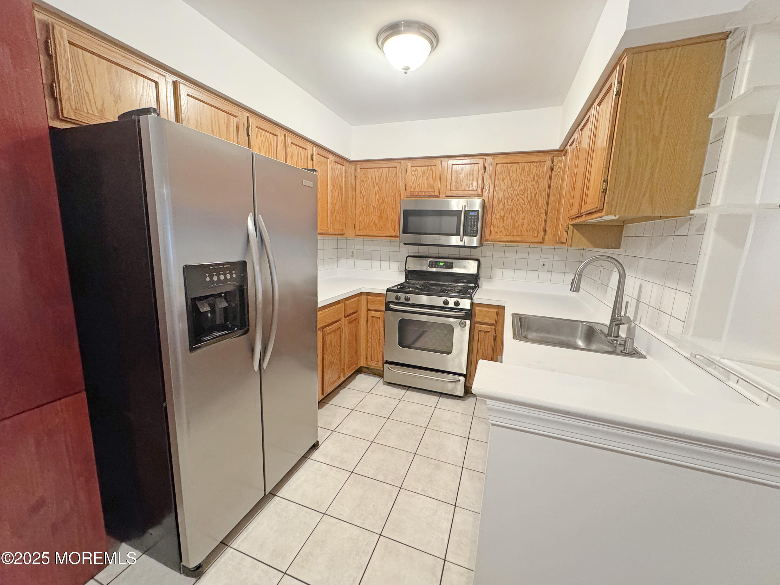 577 Windflower Court Morganville, NJ 07751 - Photo 27 of 27 a kitchen with stainless steel appliances a refrigerator sink and microwave