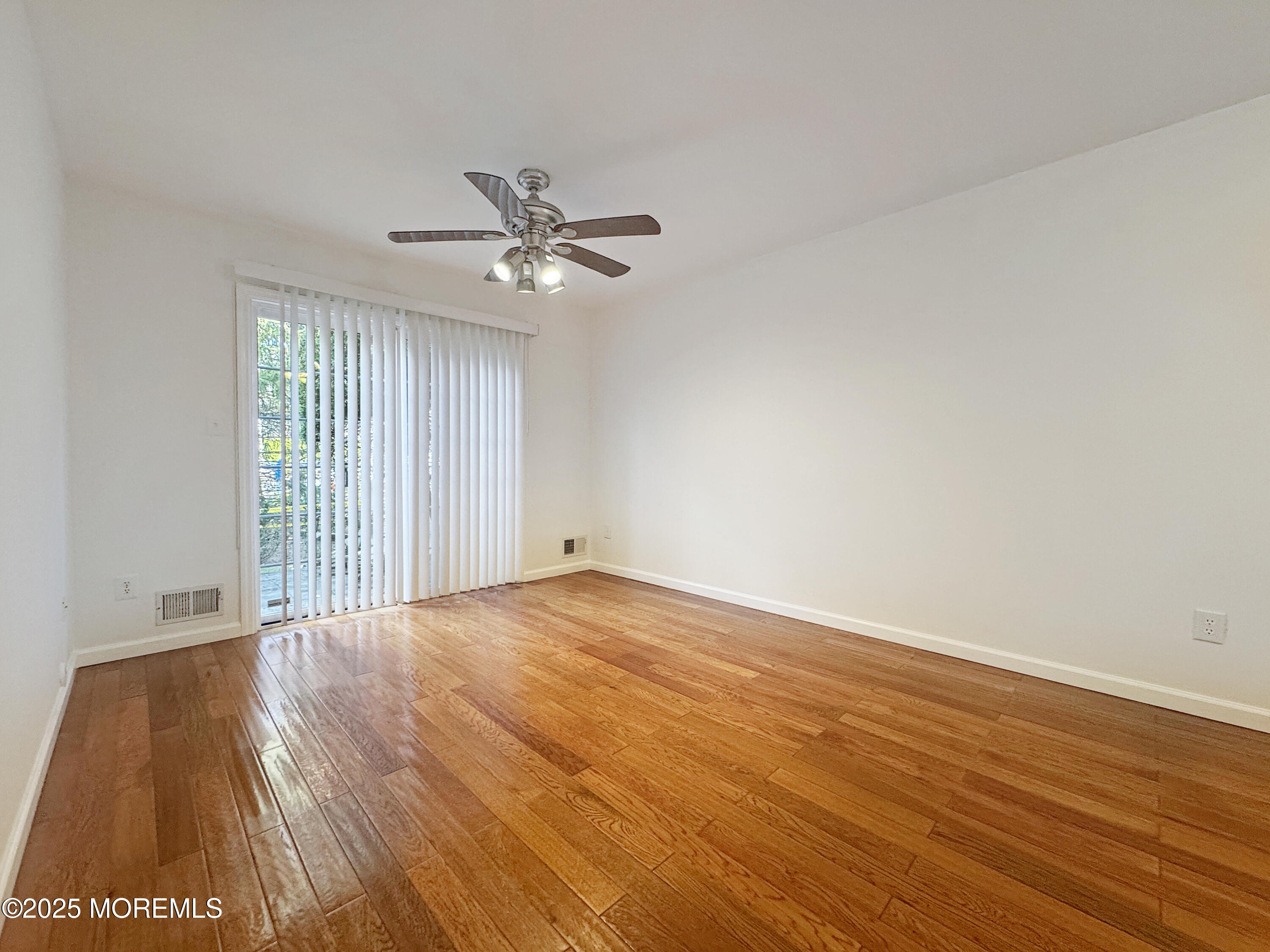 577 Windflower Court Morganville, NJ 07751 - Photo 6 of 27 a view of an empty room with wooden floor and a window