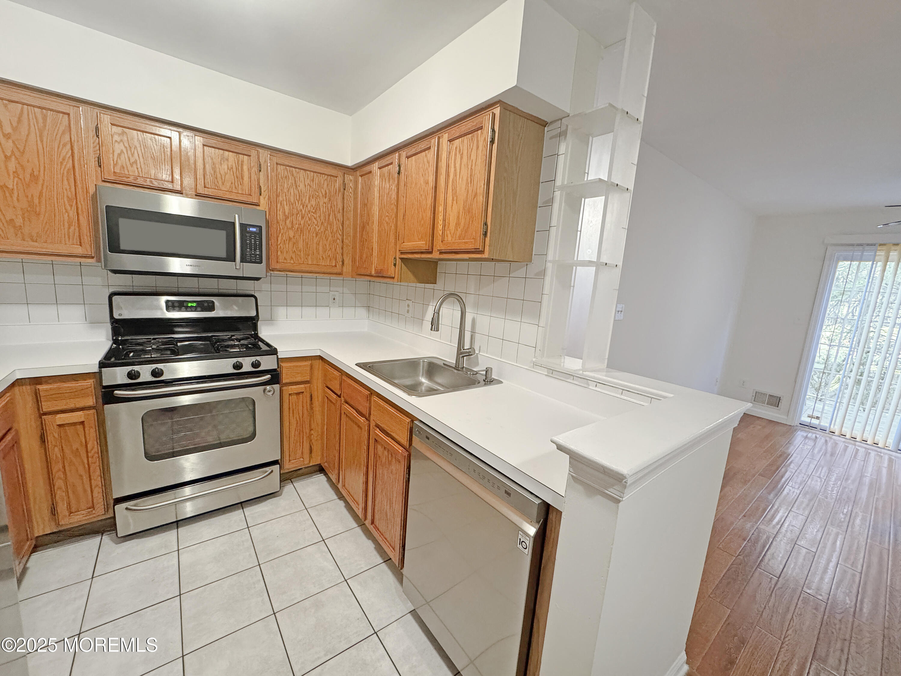 577 Windflower Court Morganville, NJ 07751 - Photo 9 of 27 a kitchen with a sink stove top oven and microwave