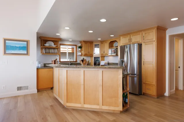 a kitchen with stainless steel appliances granite countertop a refrigerator and a stove top oven