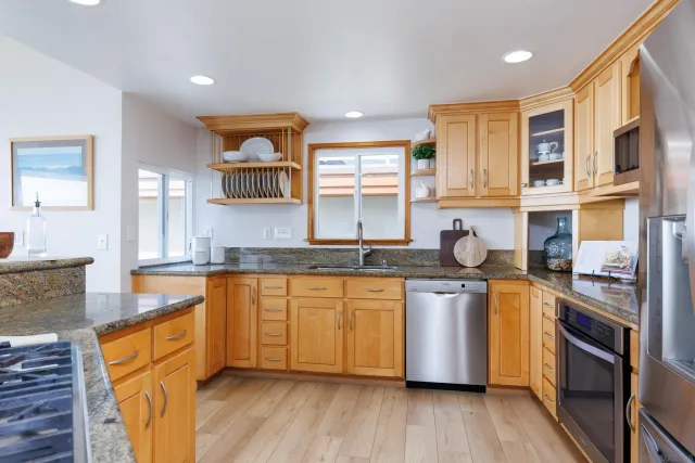a kitchen with stainless steel appliances granite countertop wooden cabinets and a stove top oven