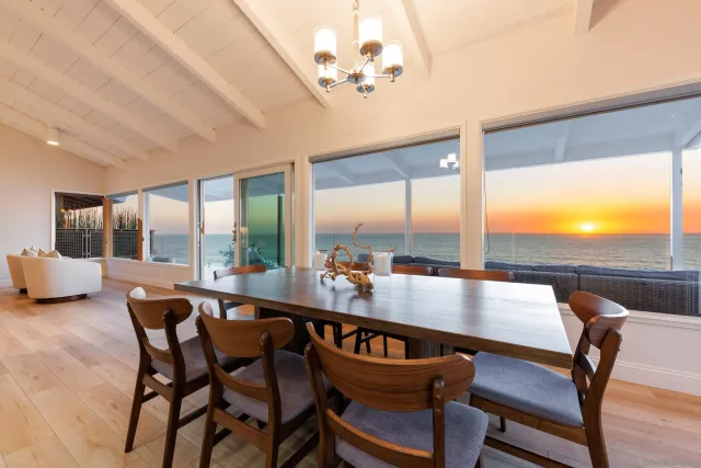 a view of a dining room with furniture large windows and wooden floor