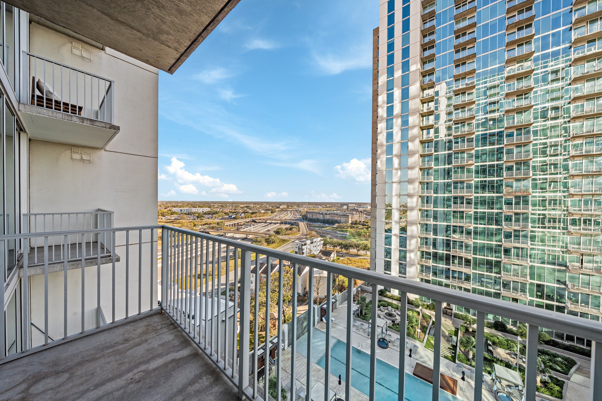 5925 Almeda Road, Unit 11406 Houston, TX 77004 - Photo 11 of 26 a view of a balcony with a floor to ceiling window stairs and wooden floor