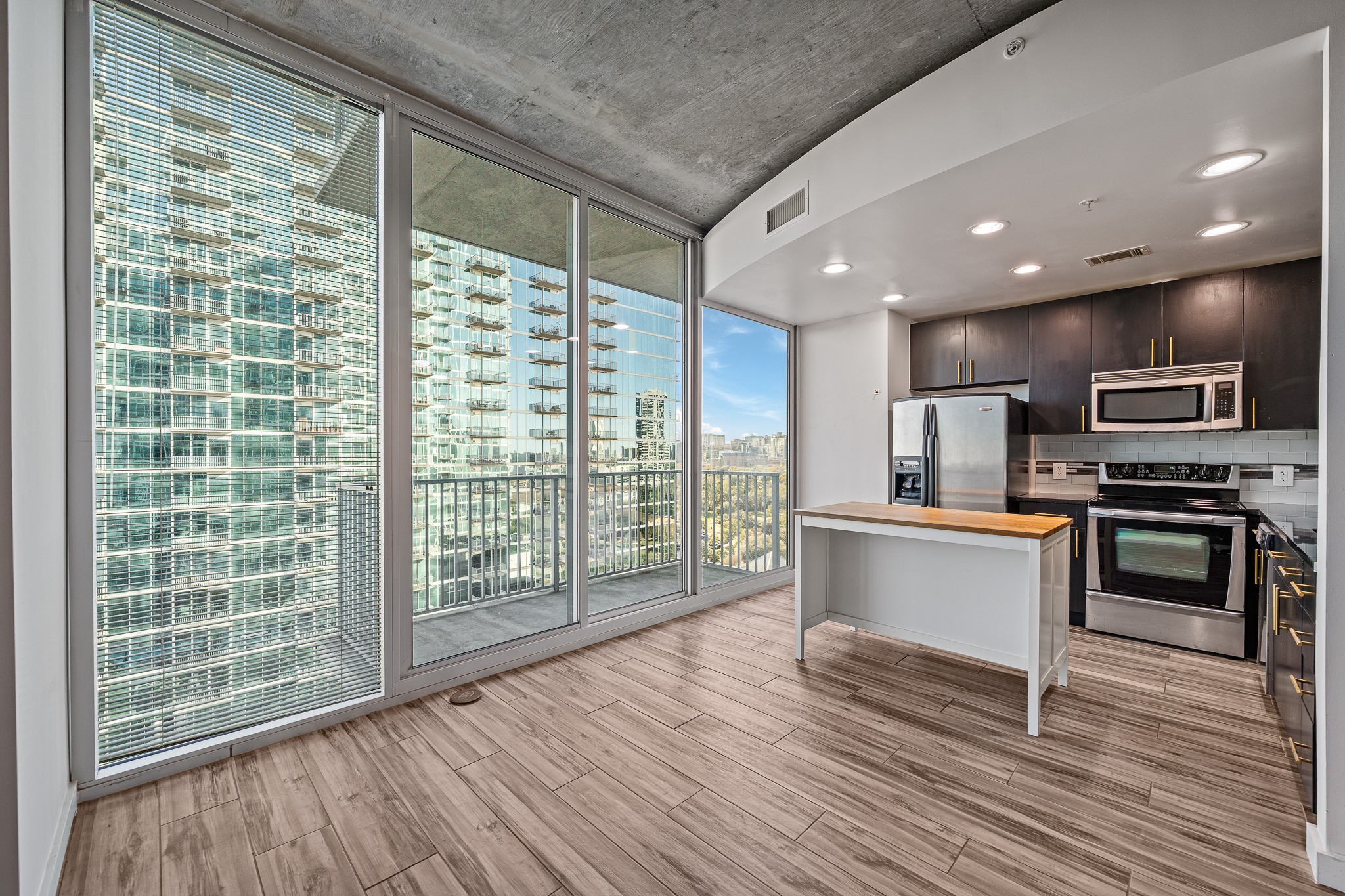 5925 Almeda Road, Unit 11406 Houston, TX 77004 - Photo 2 of 26 a open kitchen with granite countertop a stove top oven a refrigerator with white cabinets and wooden floor