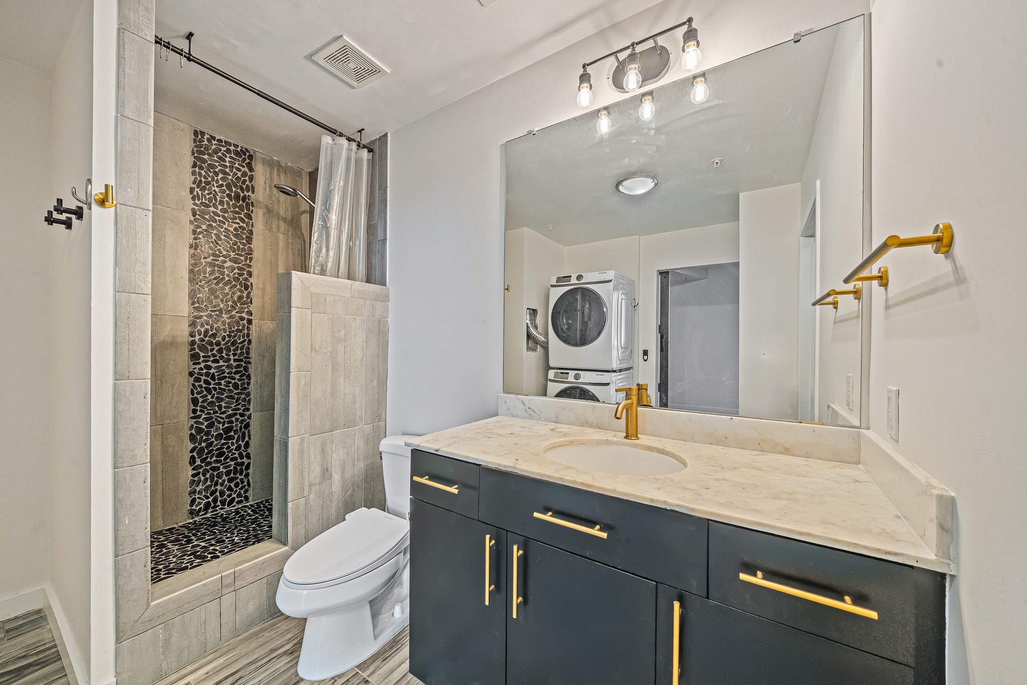 5925 Almeda Road, Unit 11406 Houston, TX 77004 - Photo 9 of 26 a bathroom with a granite countertop sink a toilet and shower