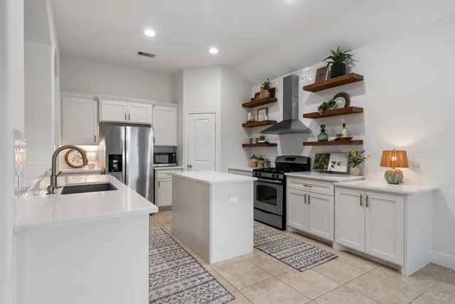 a kitchen with stainless steel appliances granite countertop a sink dishwasher stove and refrigerator