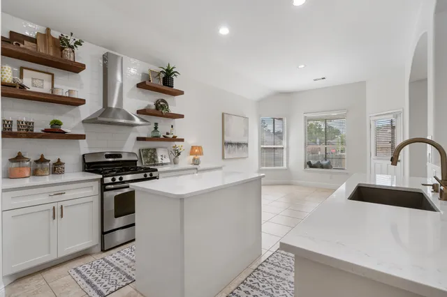 a kitchen with stainless steel appliances a sink stove and cabinets