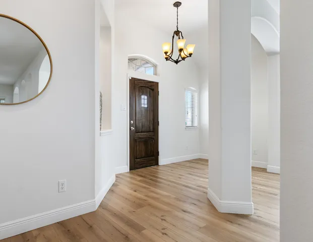 a view of a room with wooden floor and chandelier