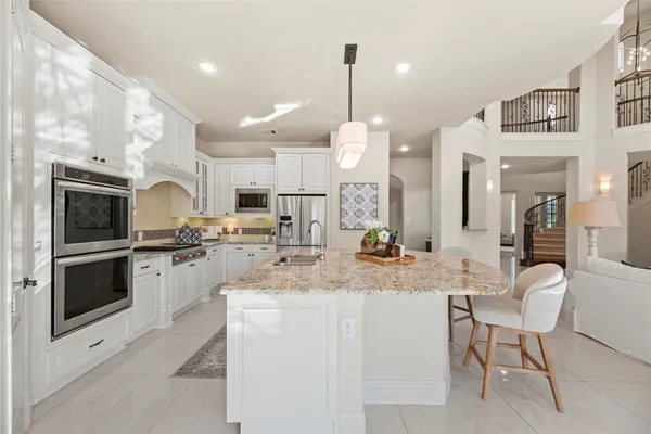 a kitchen with cabinets and chairs