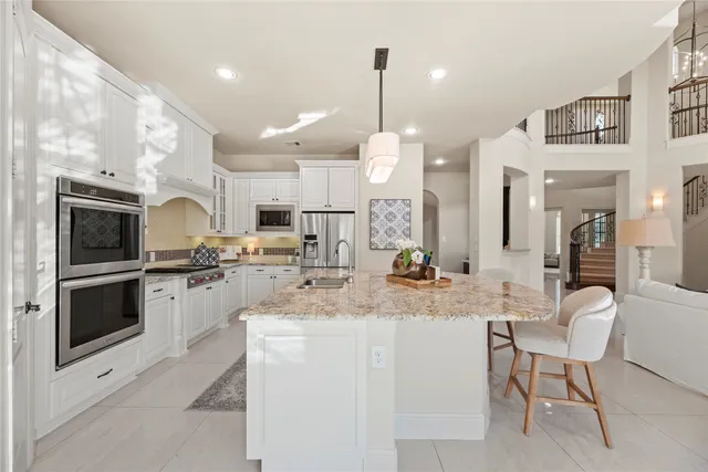 a kitchen with cabinets and chairs