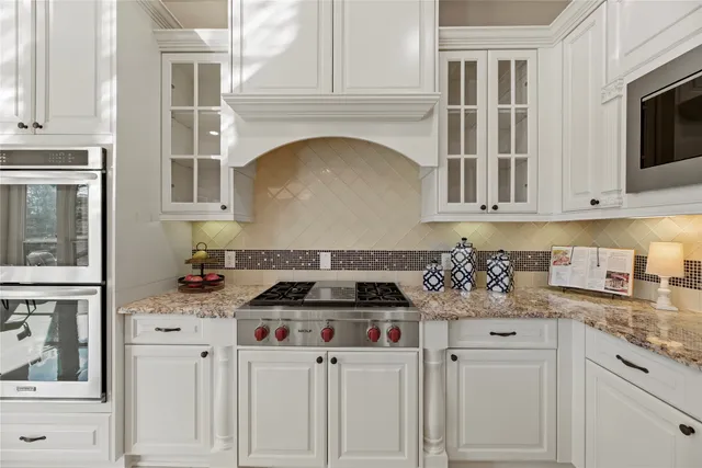 a kitchen with white cabinets and appliances
