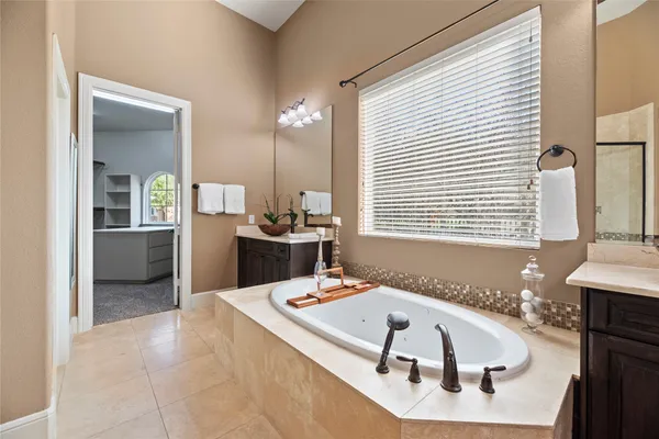 a bathroom with a tub sink and mirror