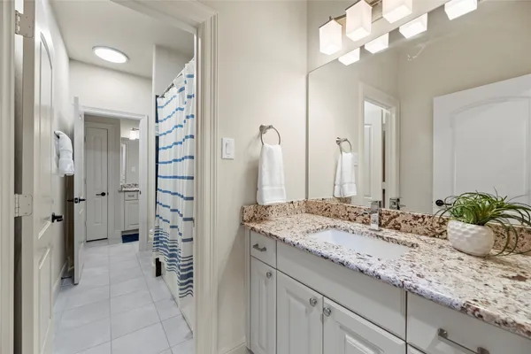 a bathroom with a granite countertop sink a shower and a mirror