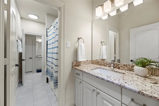 a bathroom with a granite countertop sink a shower and a mirror