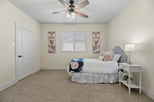 a bedroom with a bed and a chandelier fan