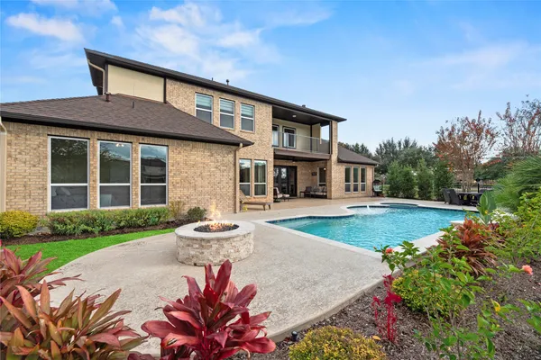 a front view of a house with a yard and fountain