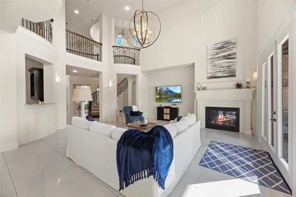 a living room with furniture a fireplace and a chandelier