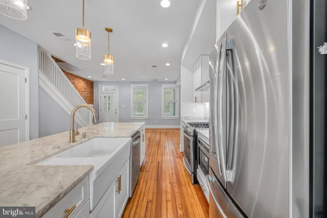a spacious bathroom with a granite countertop sink a mirror and shower