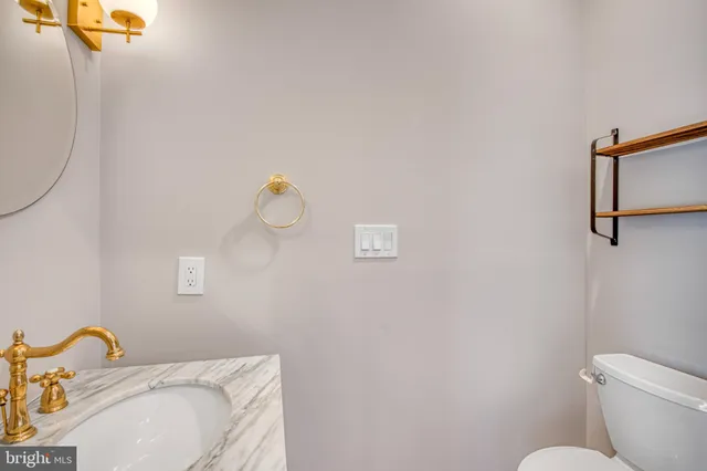 a bathroom with a sink mirror and toilet