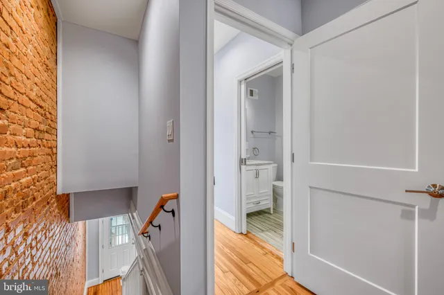 a view of a hallway with a livingroom and a bathroom with a sink