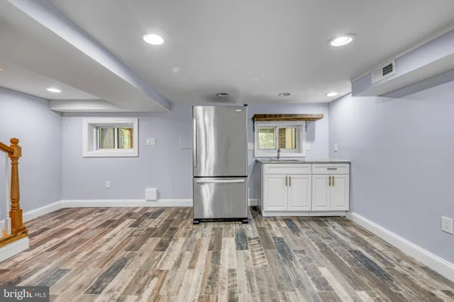 a view of kitchen with a refrigerator cabinets and wooden floor