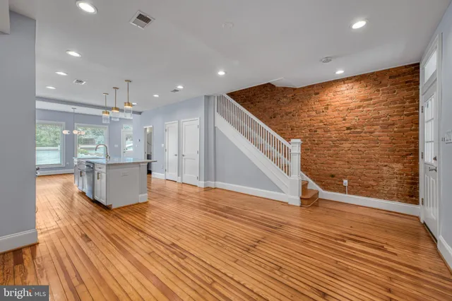 a view of a living room with wooden floor and floor to ceiling window