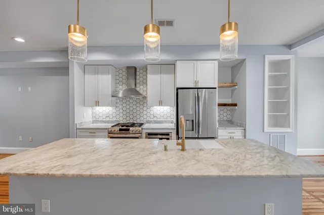 a kitchen with kitchen island granite countertop cabinets and refrigerator