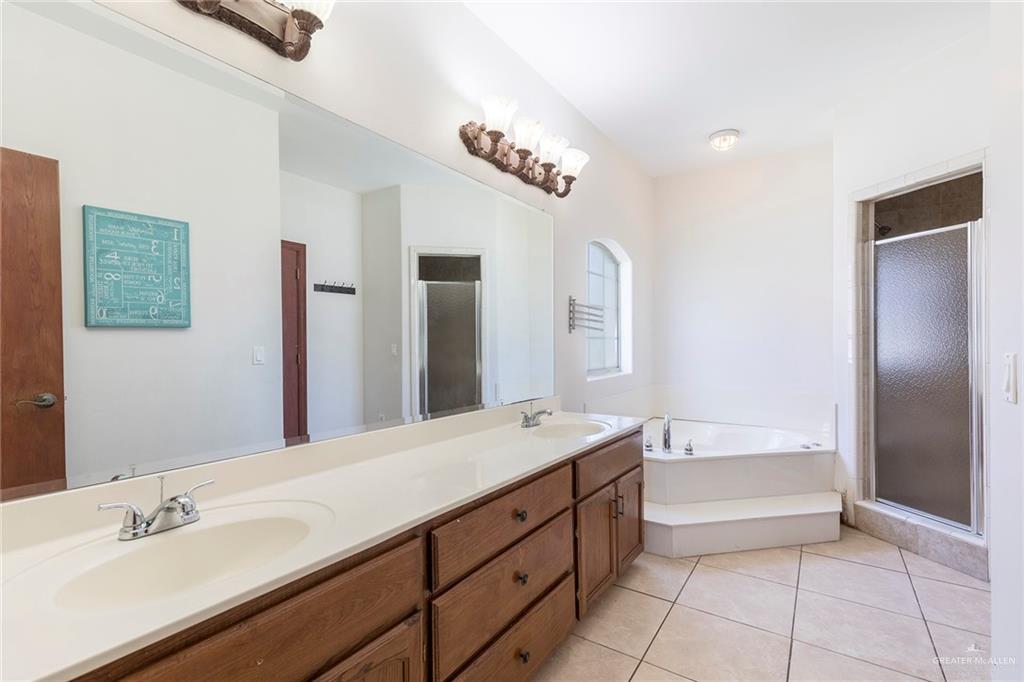 1213 Rhett Drive Pharr, TX 78577 - Photo 11 of 19 Luxurious primary bathroom with dual vanities, soaking tub, and separate shower.