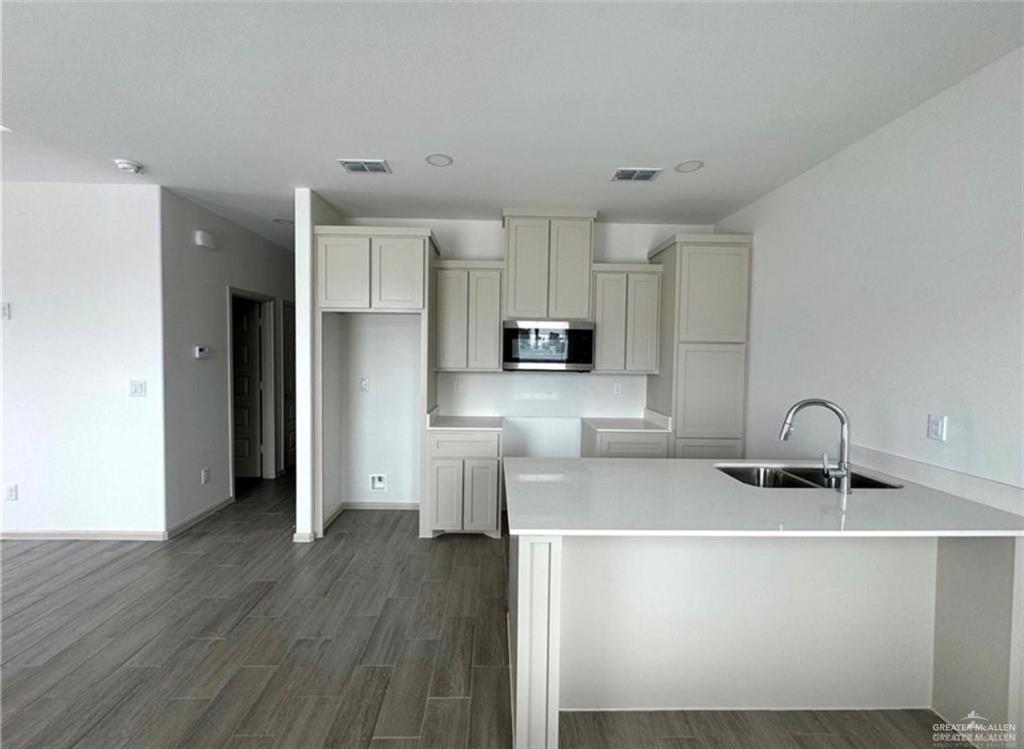 7710 North 58th Street, Unit 2 Mission, TX 78573 - Photo 3 of 13 a kitchen that has a lot of cabinets and wooden floor