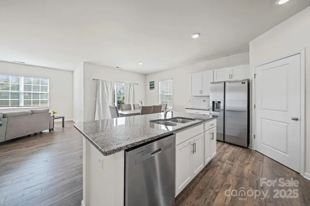 a kitchen with stainless steel appliances granite countertop a sink stove and refrigerator