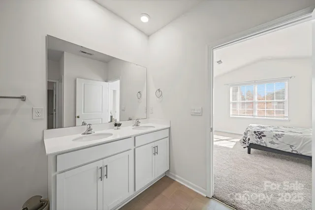 a spacious bathroom with a granite countertop sink and a mirror