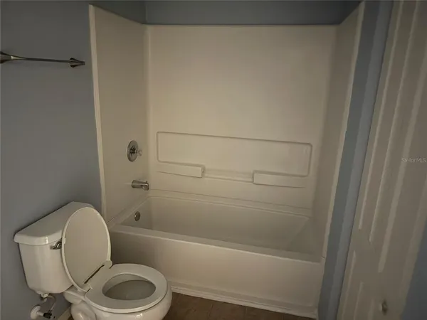 a white toilet sitting next to a bath tub