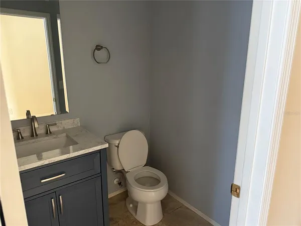 a bathroom with a granite countertop toilet and a sink
