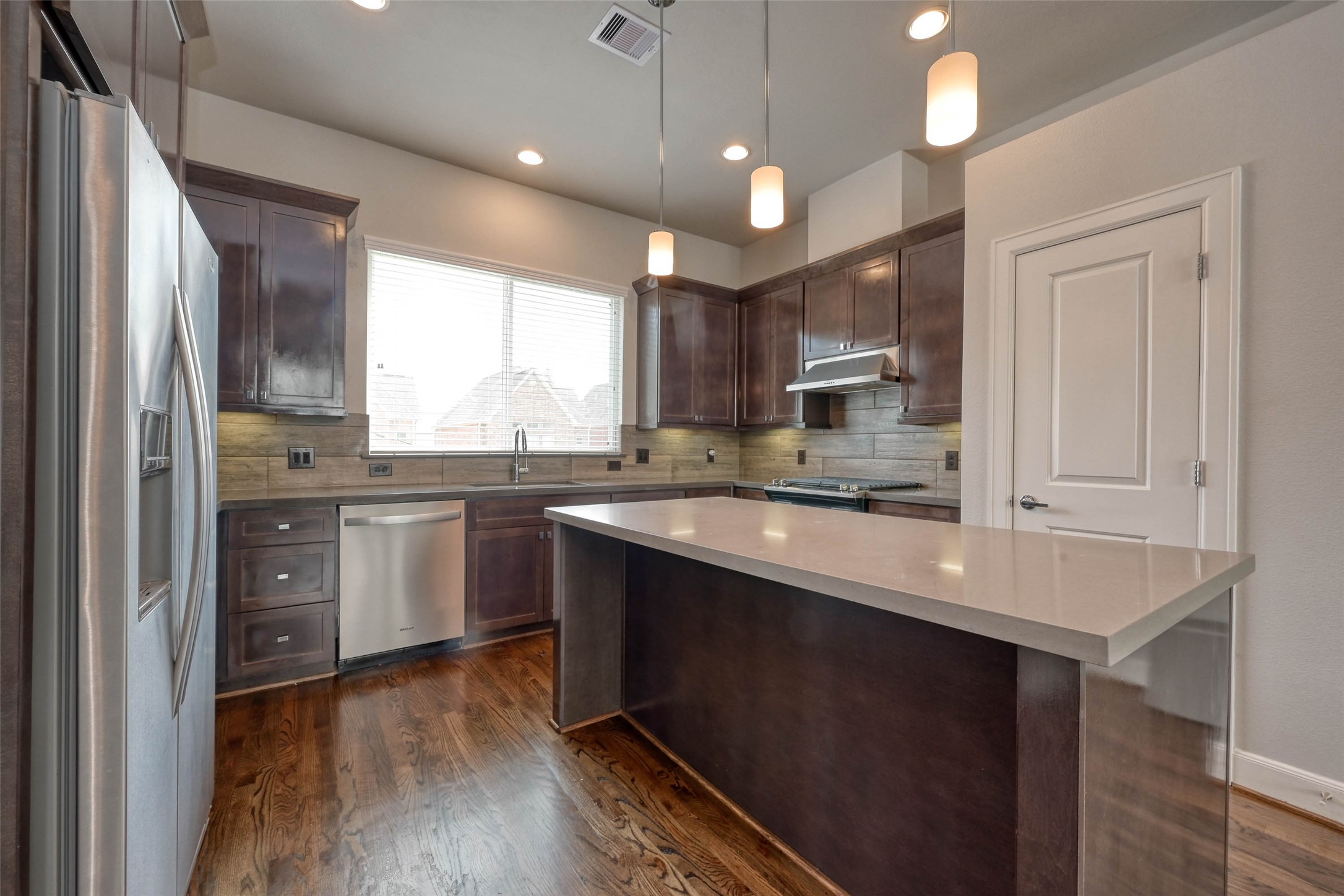 951 West 17th Street Houston, TX 77008 - Photo 13 of 30 a kitchen with stainless steel appliances granite countertop a sink a stove a refrigerator cabinets and a large window