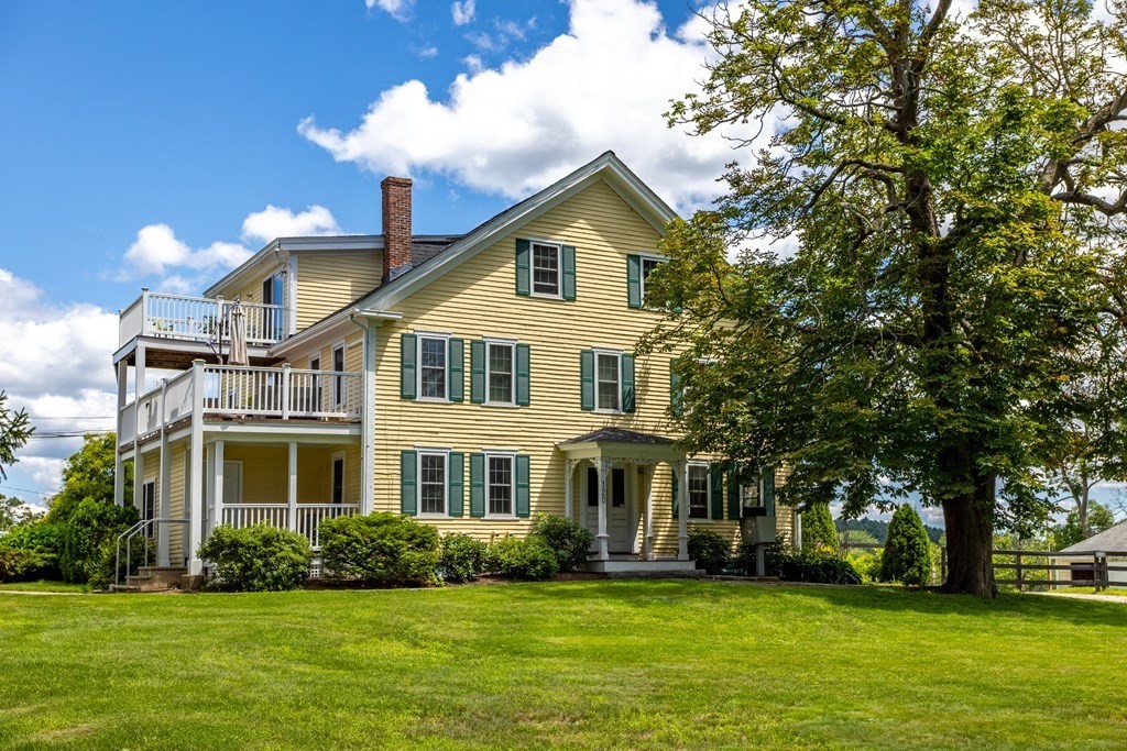 120 Goldsmith Street, Unit 3 Littleton, MA 01460 - Photo 2 of 33 a view of a white house with a big yard and potted plants and large trees