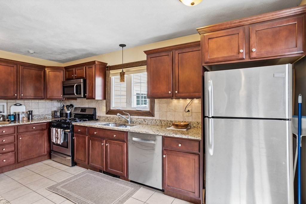 120 Goldsmith Street, Unit 3 Littleton, MA 01460 - Photo 7 of 33 a kitchen with stainless steel appliances granite countertop a refrigerator stove a sink dishwasher and wooden cabinets