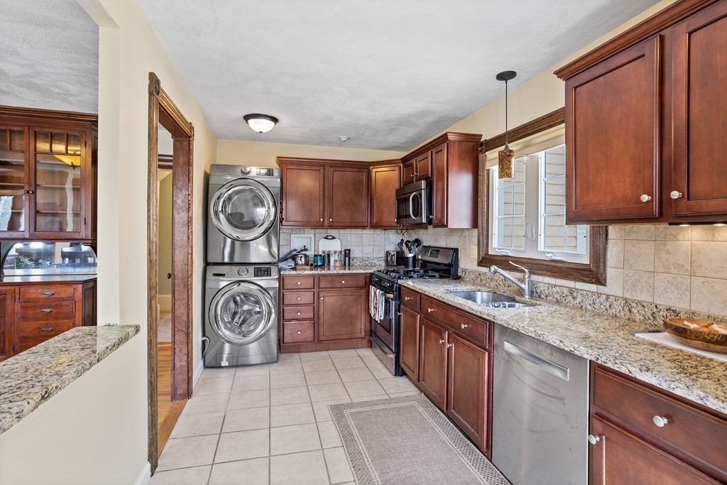 120 Goldsmith Street, Unit 3 Littleton, MA 01460 - Photo 8 of 33 a kitchen with kitchen island granite countertop a stove top oven sink and cabinets