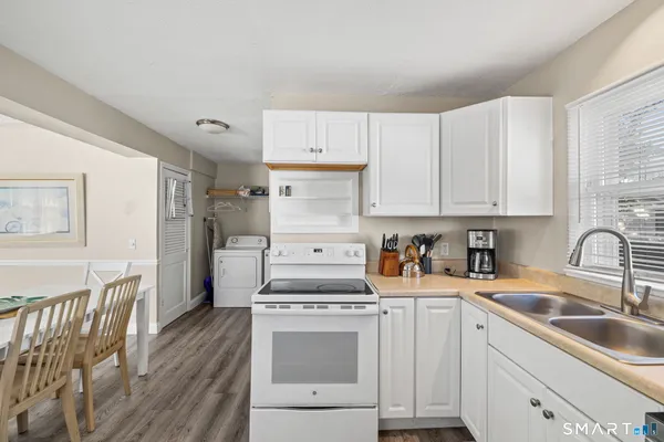 a kitchen with granite countertop white cabinets and white appliances