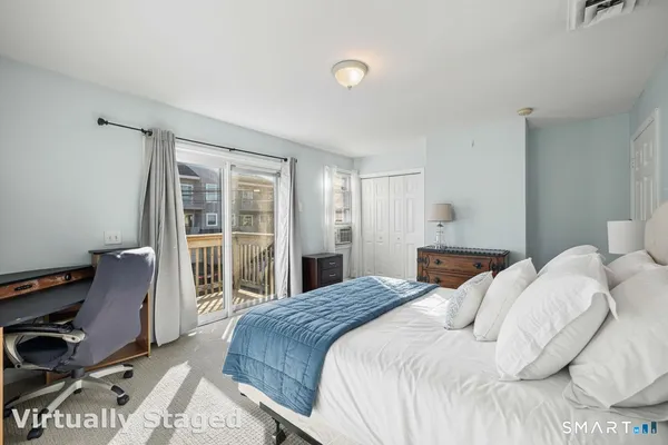 a bedroom with a bed and a large window