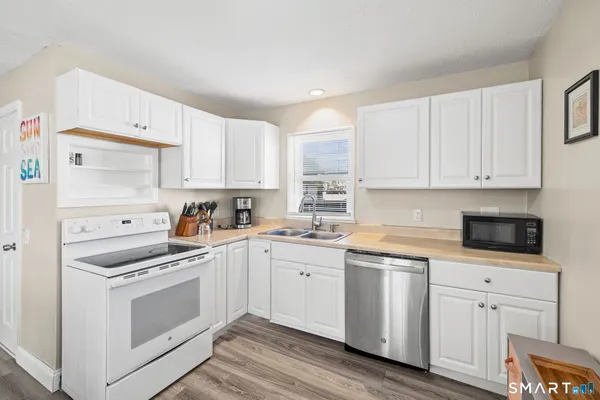 a kitchen with white cabinets stainless steel appliances and sink