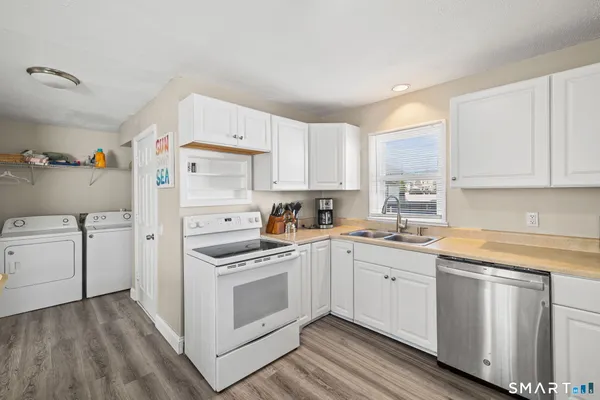 a kitchen with white cabinets sink and white appliances