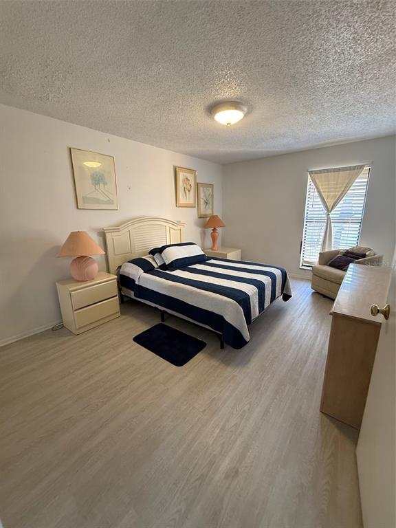 6206 Raintree Drive, Unit GE Orlando, FL 32822 - Photo 15 of 18 a spacious bedroom with a bed and a couch
