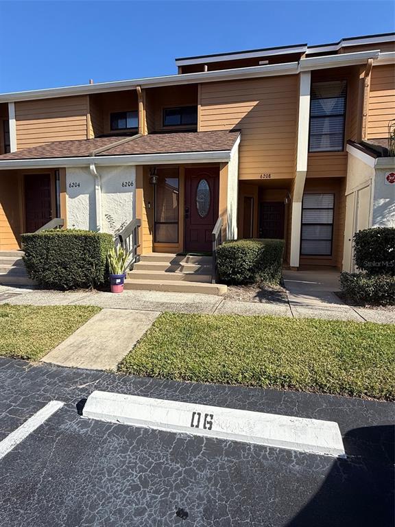 6206 Raintree Drive, Unit GE Orlando, FL 32822 - Photo 2 of 18 a front view of a house with a yard and garage